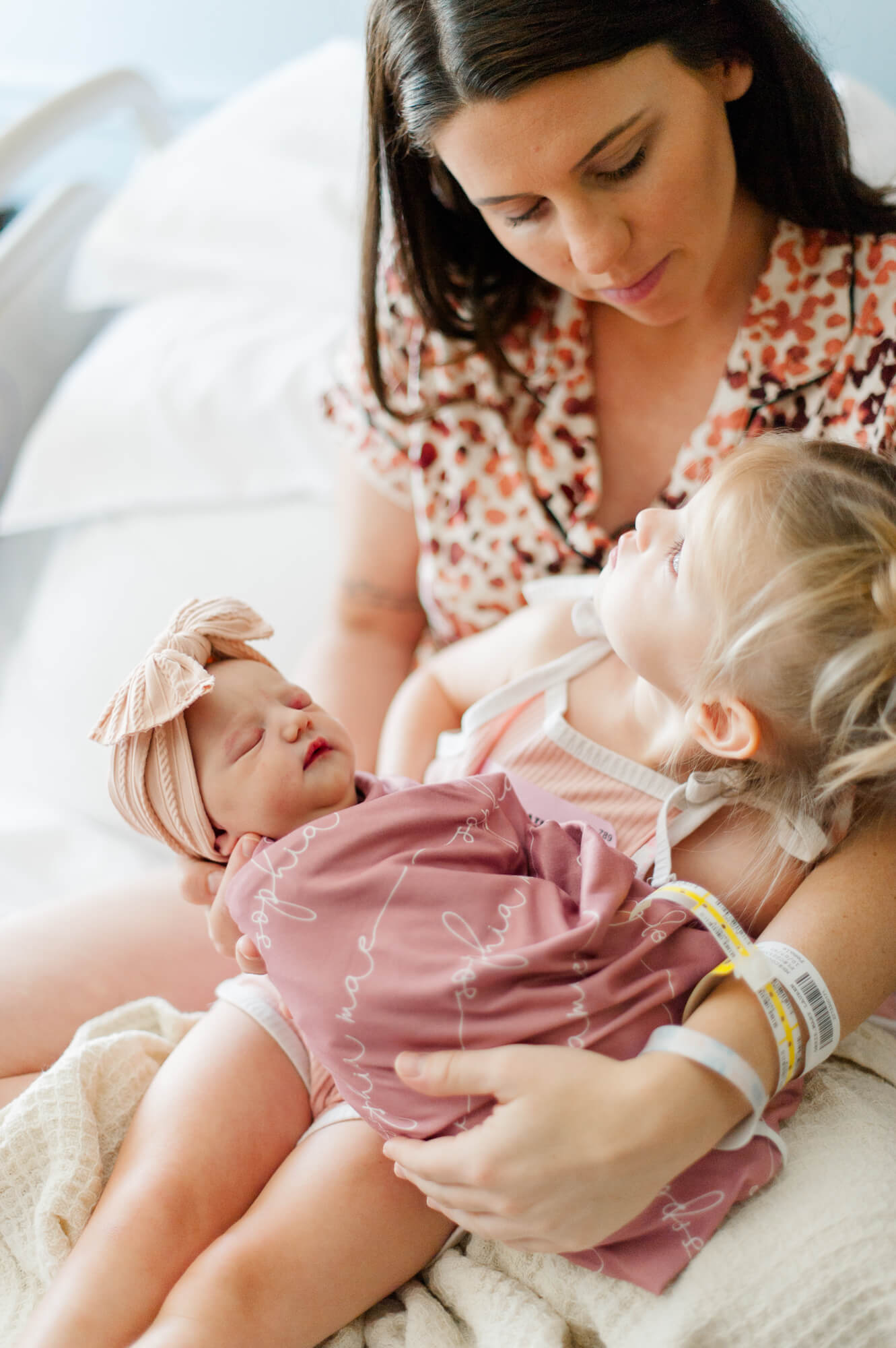 Newborn mother holds her baby and introduces her firstborn daughter to her little sister at Holmes Labor and Delivery