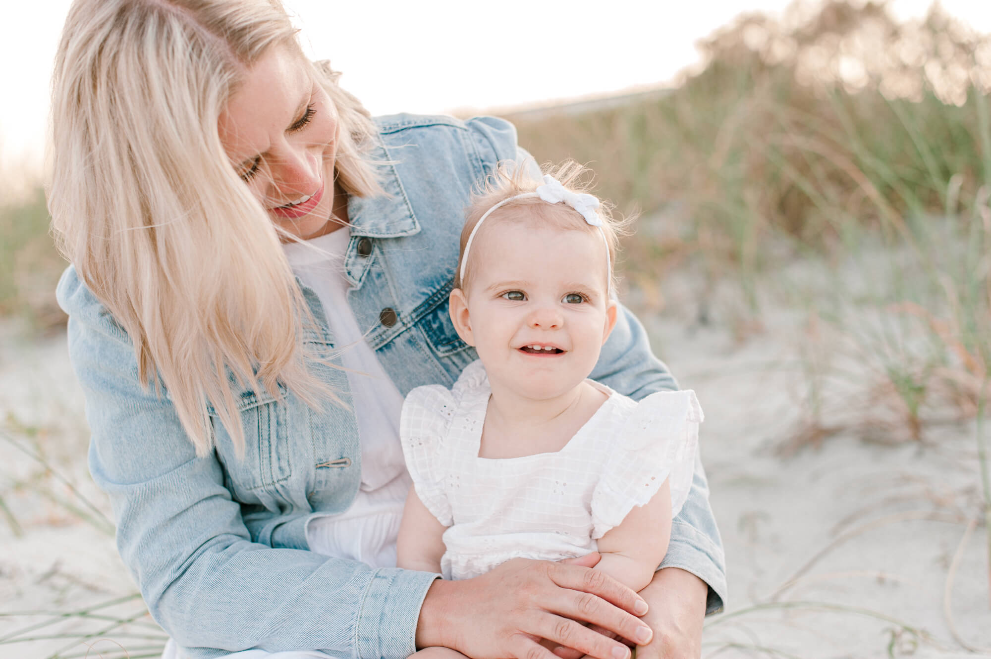 Mom admiring her beautiful daughter on the beach during a family session. Viera Pediatric Dentistry would be a perfect fit for her children.