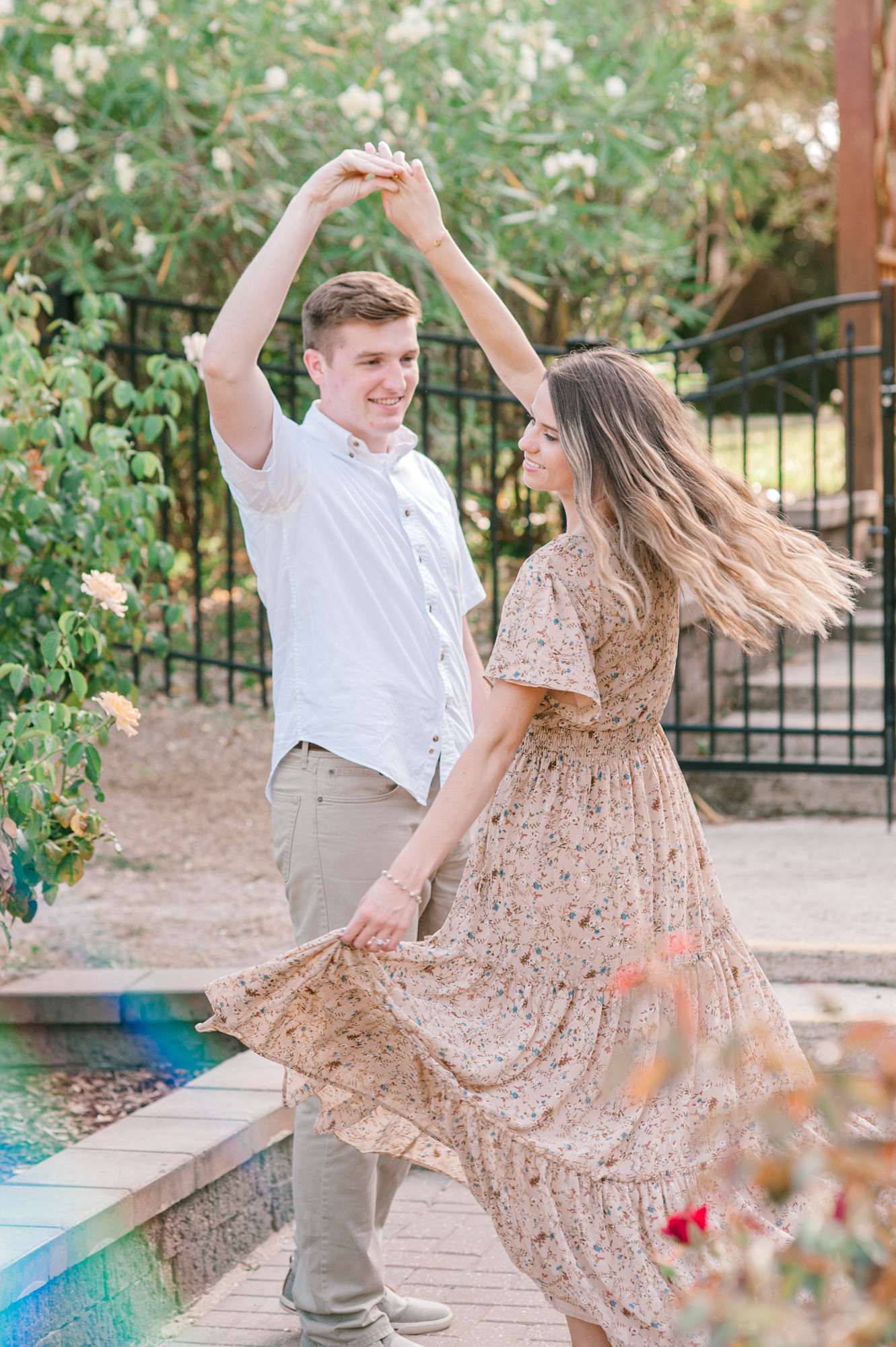 Newly engaged couple dancing in the rose garden during their engagement photos in St. Augustine, Florida. 