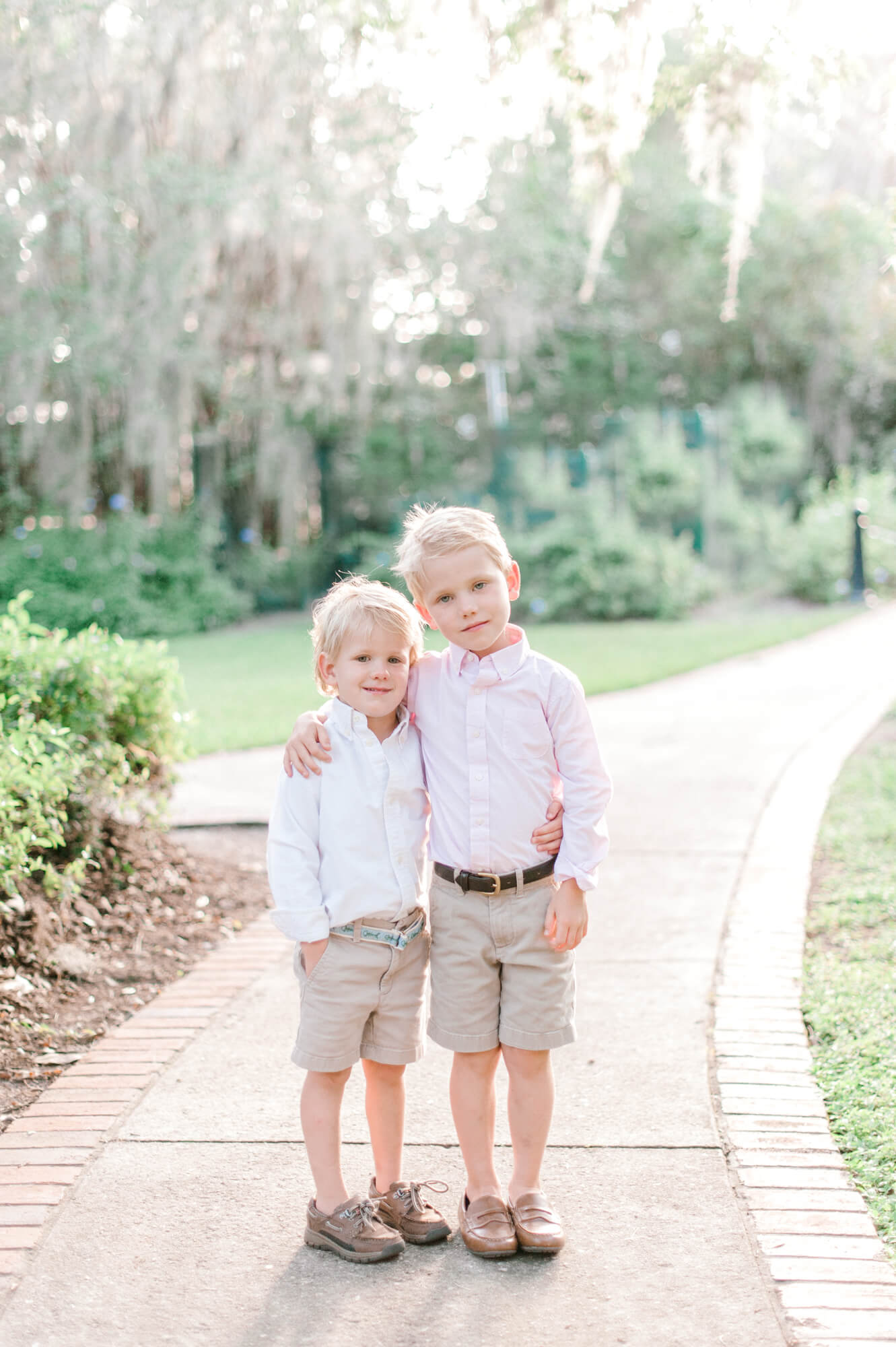 Two young brothers pose for a photo on a walkway in Cypress Grove Park.