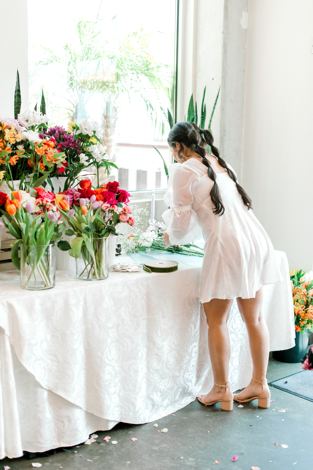 The bride making a flower bouquet at her flower bar in the private event room at The Landing Rooftop.