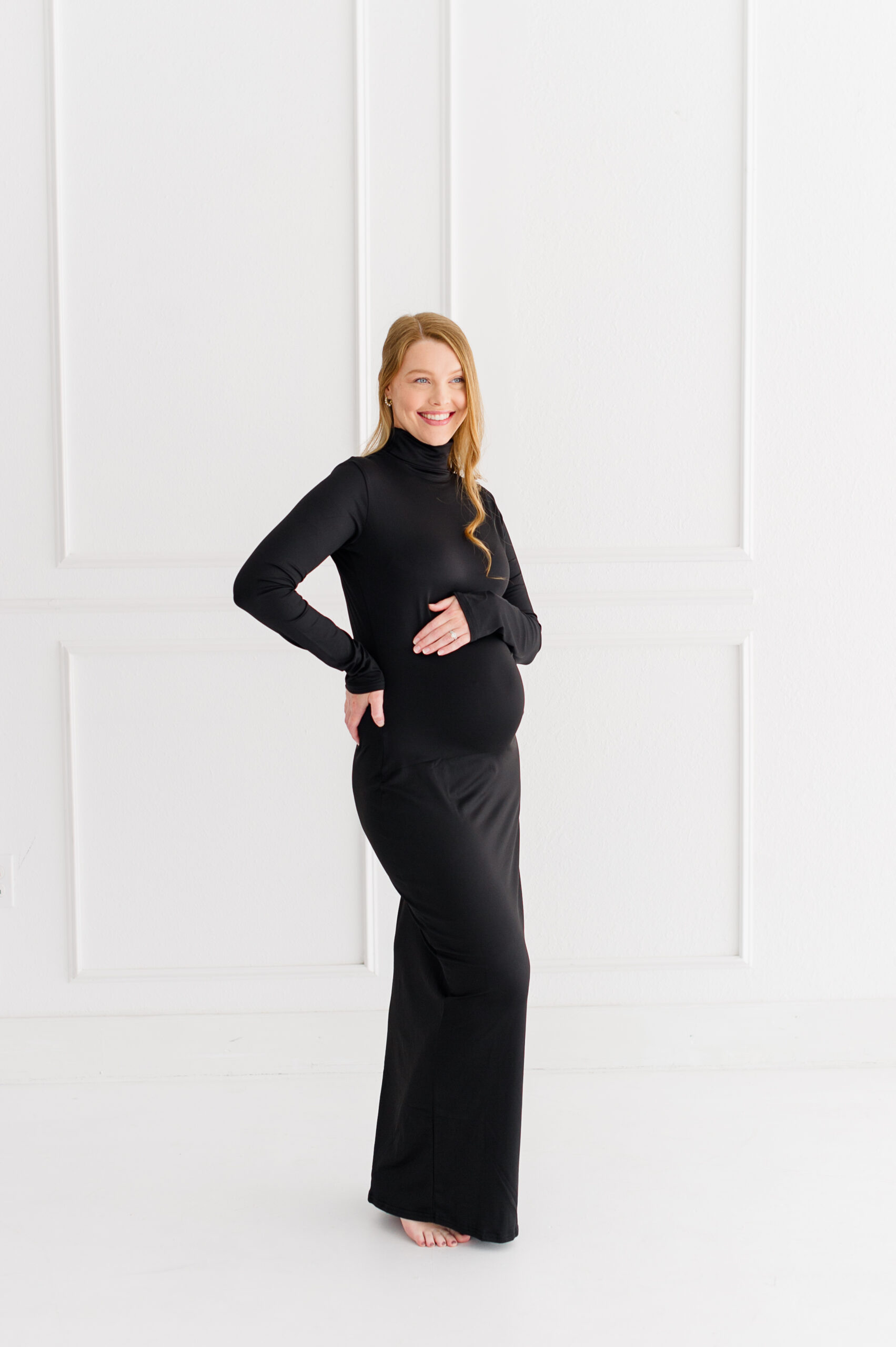 Beautiful glowing mother takes studio maternity photos wearing all black to celebrate 20 weeks pregnant in a natural light studio in Orlando, Florida.