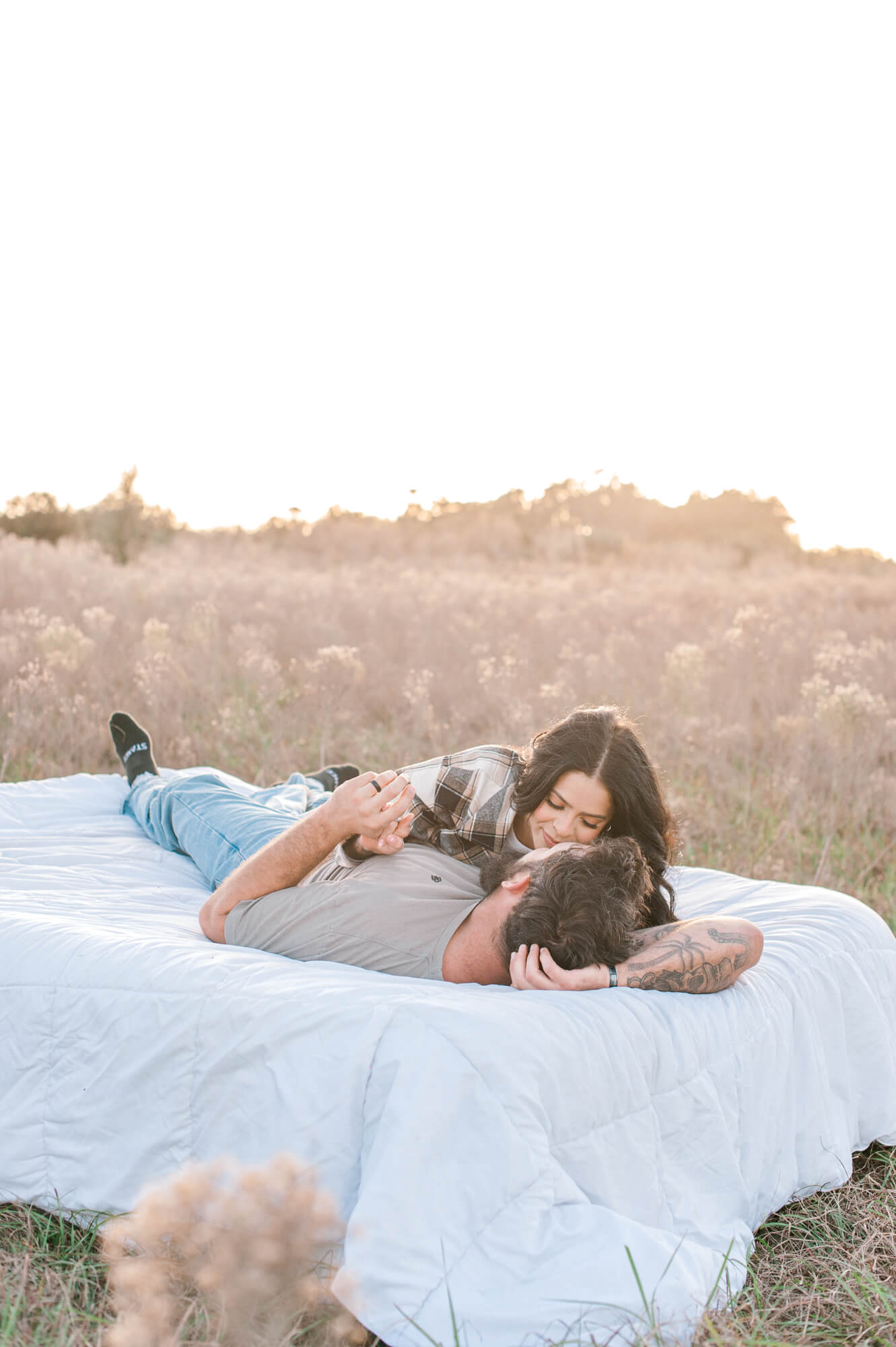 The cutest couple laying together in a field at sunset chatting about their favorite yoga studio, The Yoga Garden in Orlando, Florida. 