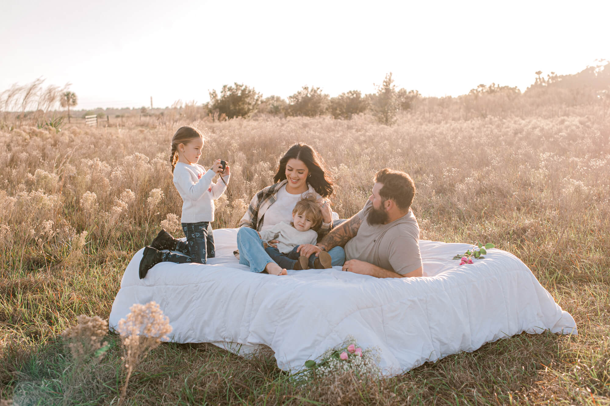 Pearl Pediatric Dental would be a perfect fit for this family of four sitting on an air mattress in a beautiful field at golden hour.