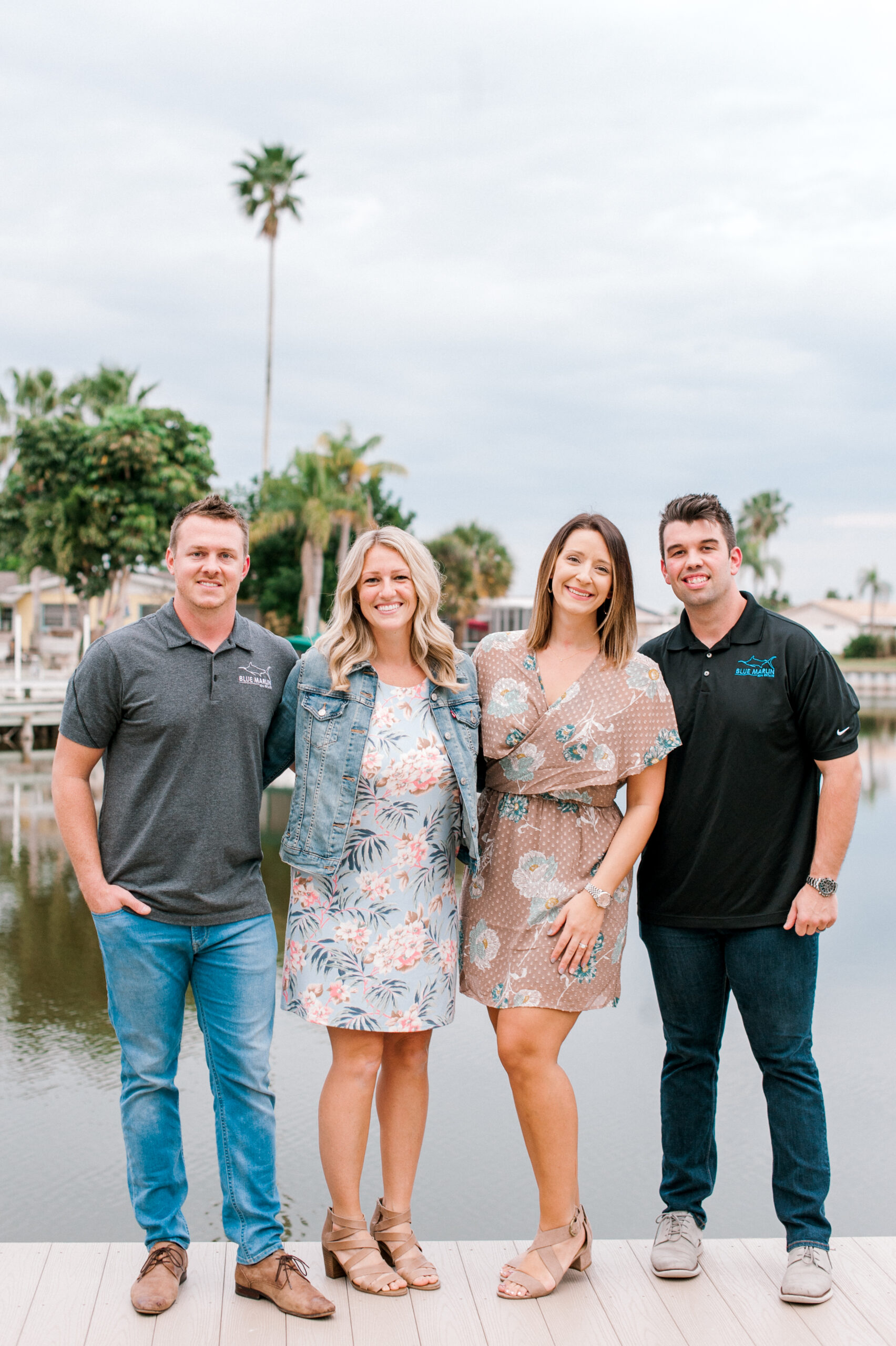 Portrait photo of the owners of Blue Marlin Real Estate standing on the dock in front of a canal in Merritt Island, Florida.