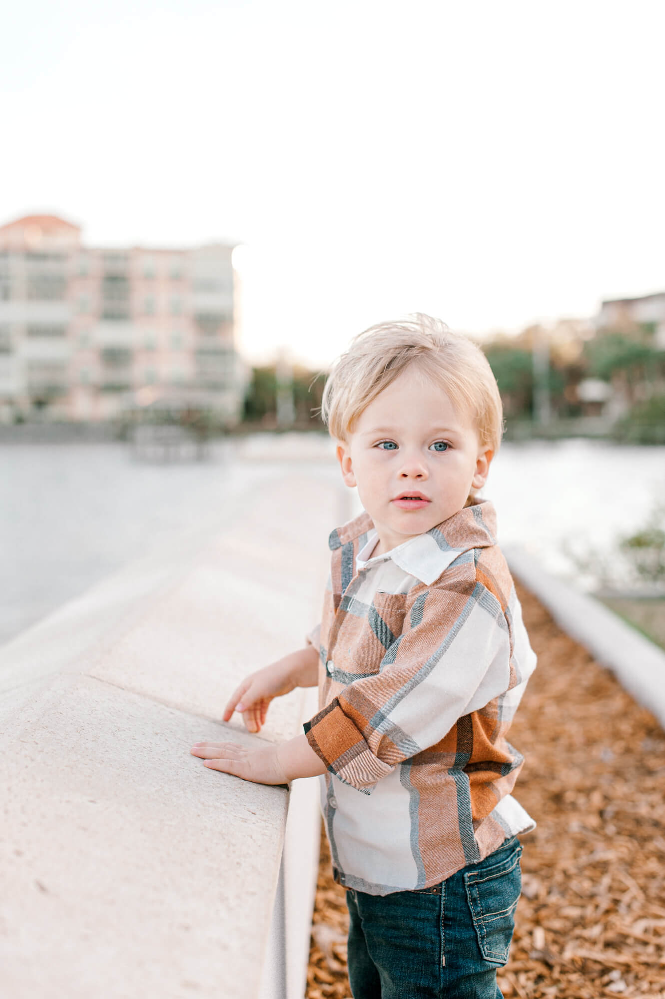 The sweetest boy standing by water near Coral Reef Academy looking over his shoulder during a family photoshoot.