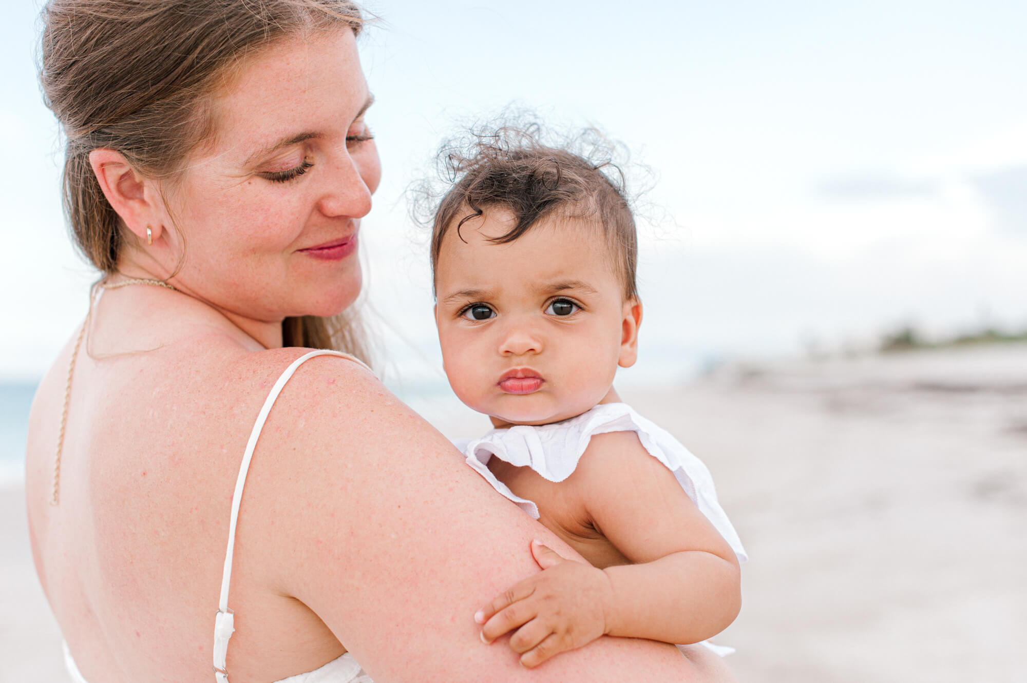 Closeup of a mom holding her daughter on the beach at the Grand Harbour Beach Club east of Orlando.