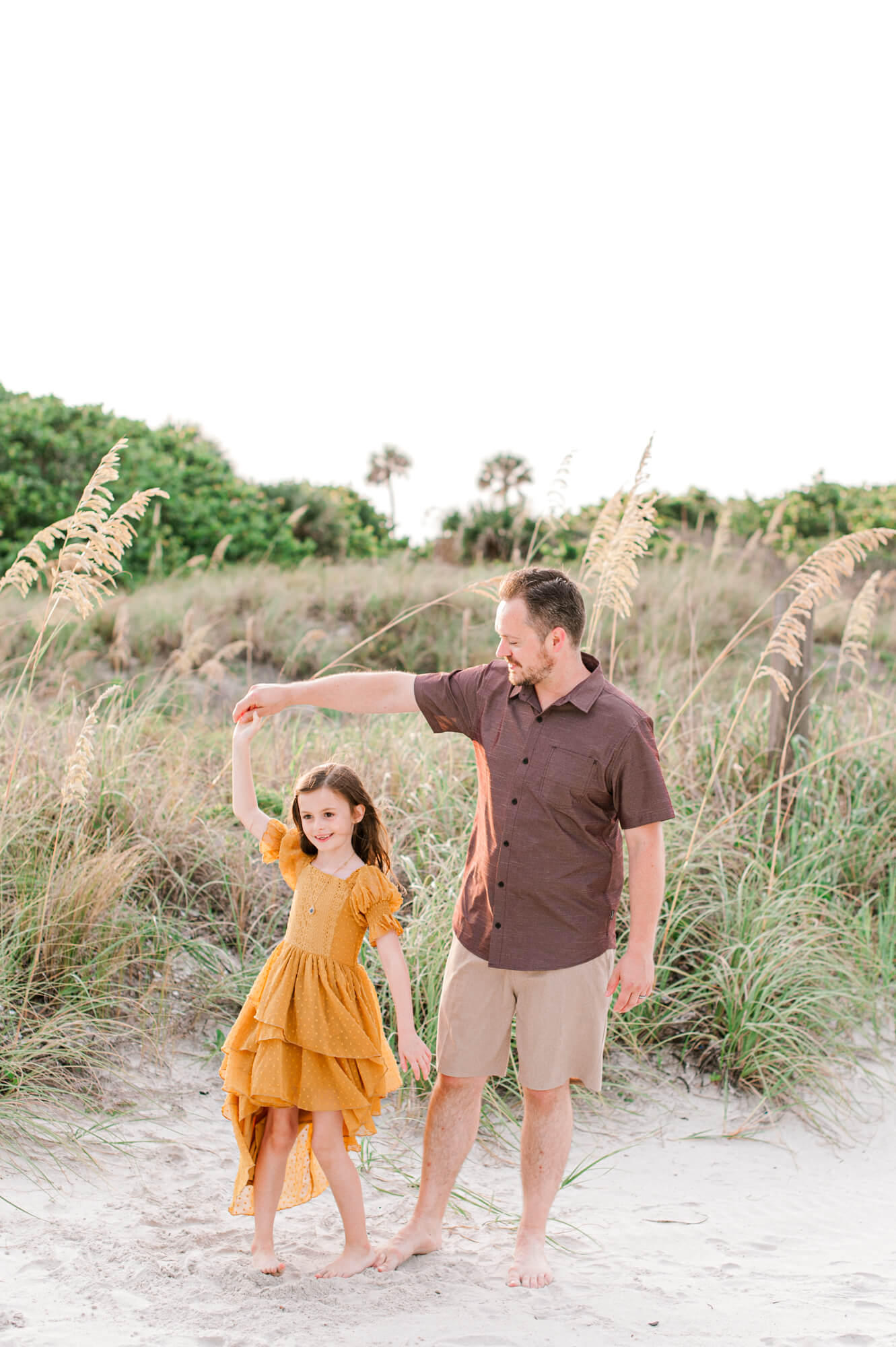Dad dancing with his daughter on the beach near the dunes things to do in Orlando with kids