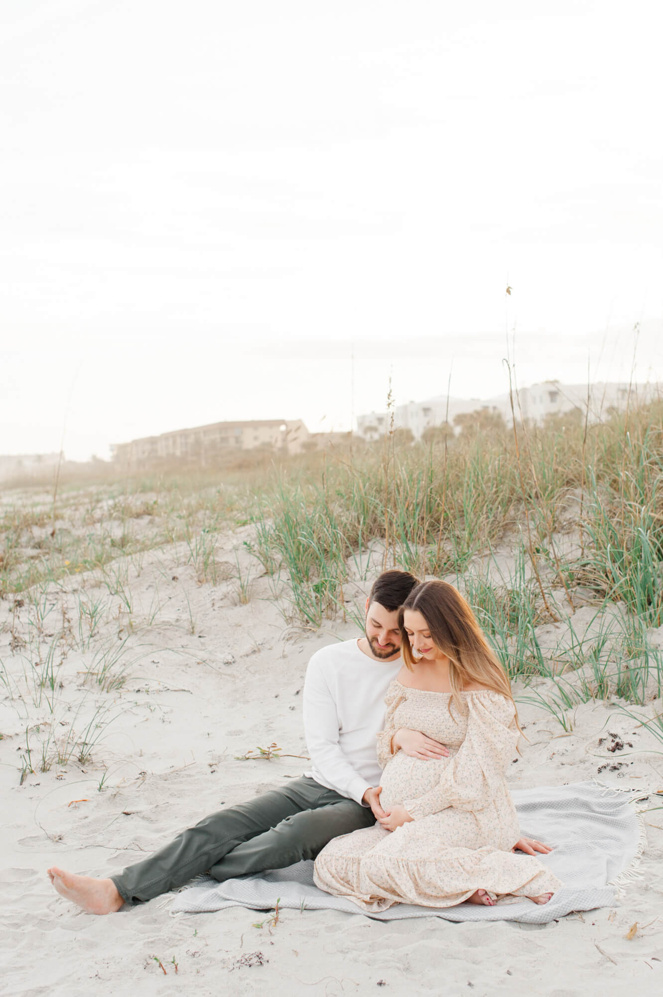 New parents to be sitting in the dunes cherishing their last moments before becoming parents 