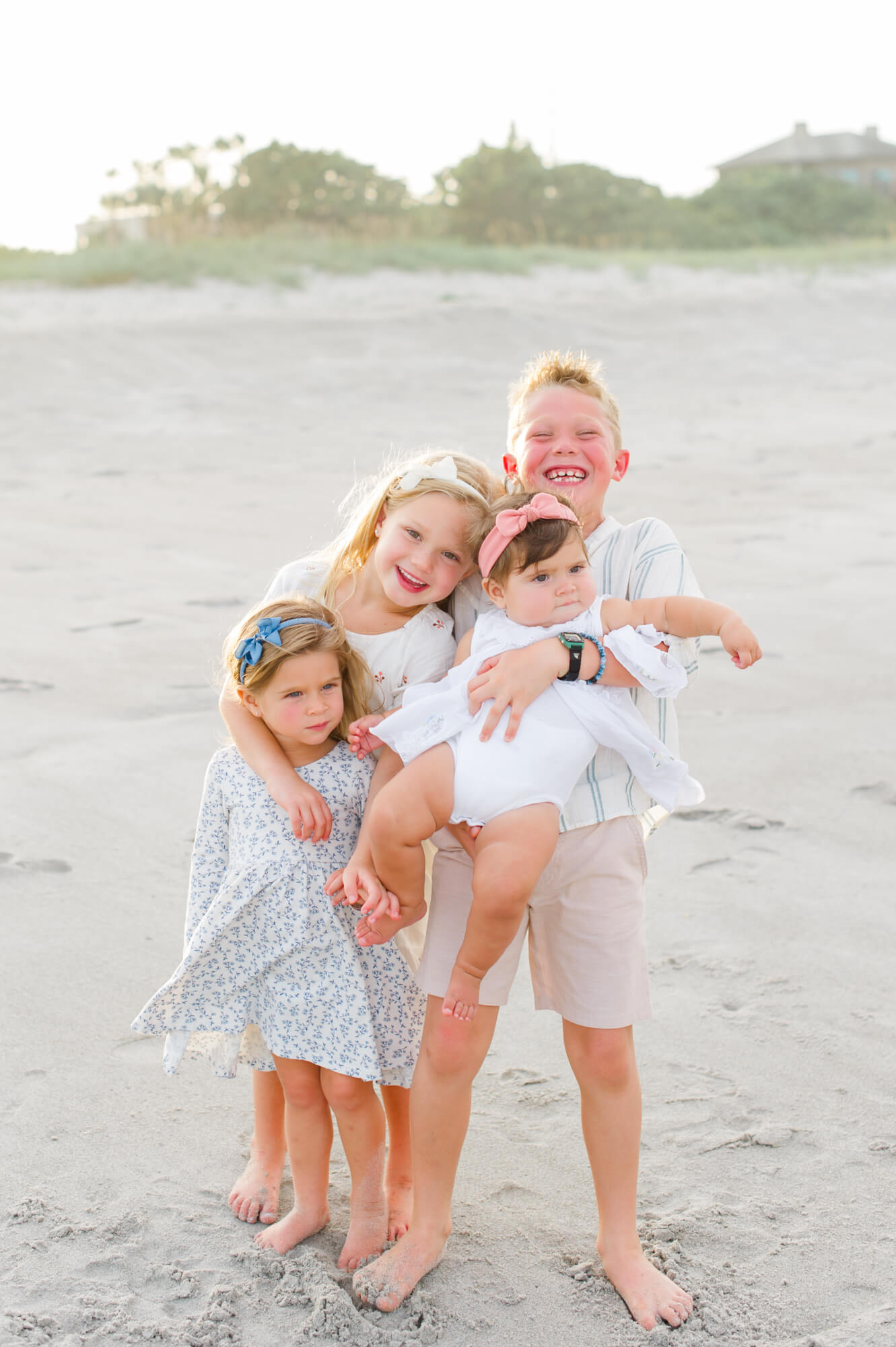 Adorable siblings all hugged in close for a photo on the beach Orlando toy stores