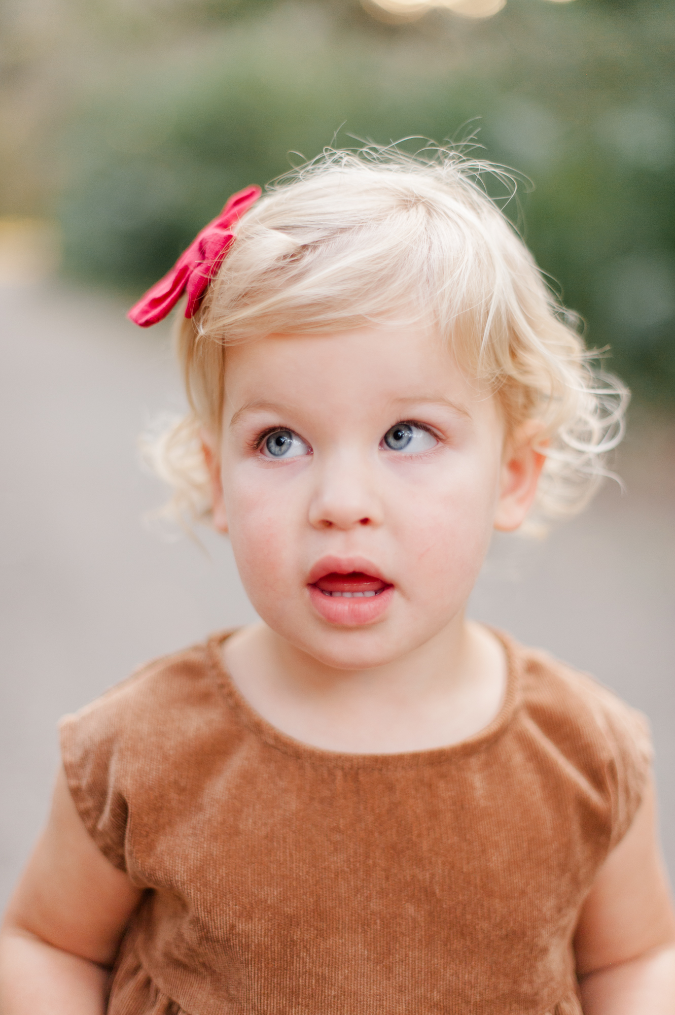 Close up of sweet blonde hair blue eyed girl with red bow