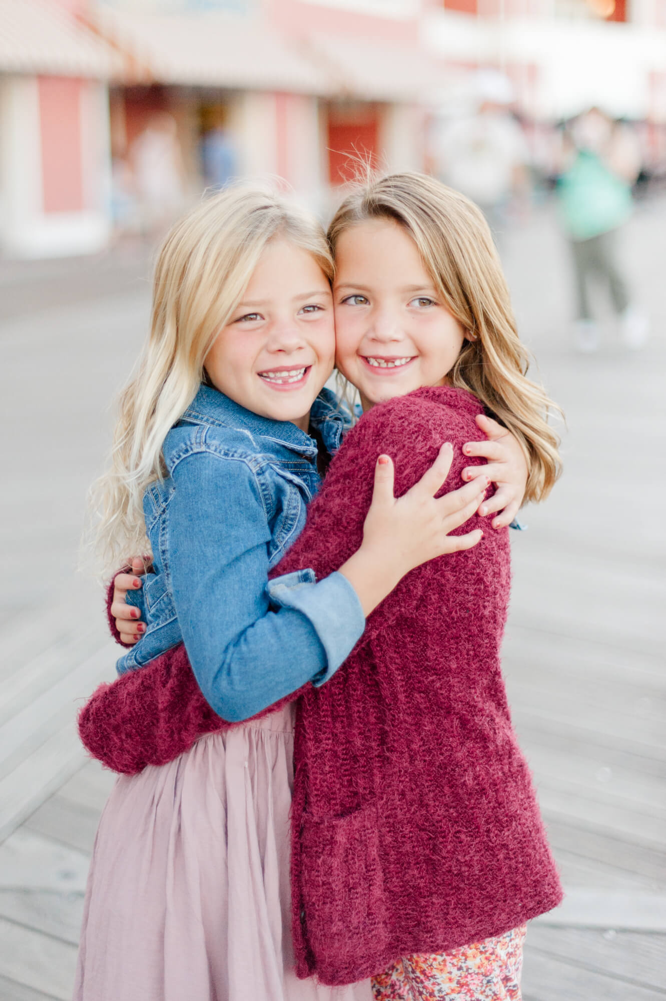 Two sisters hugging tight on the Disney Boardwalk during their family photo session