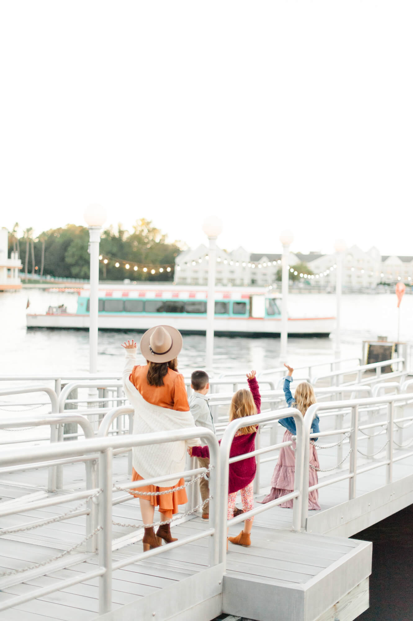 Adorable family waving goodbye to the boat at the Disney Boardwalk Resort in Walt Disney World