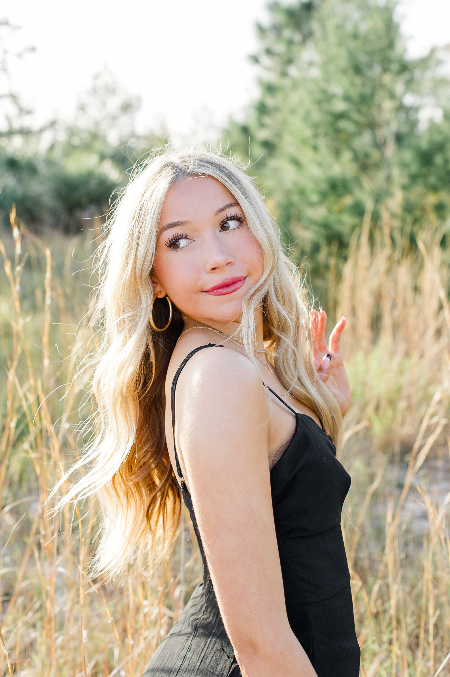 Stunning blonde senior girl from Timber Creek High looks back over her shoulder during her senior photo session with Orlando photographer M. Lauren Photography.