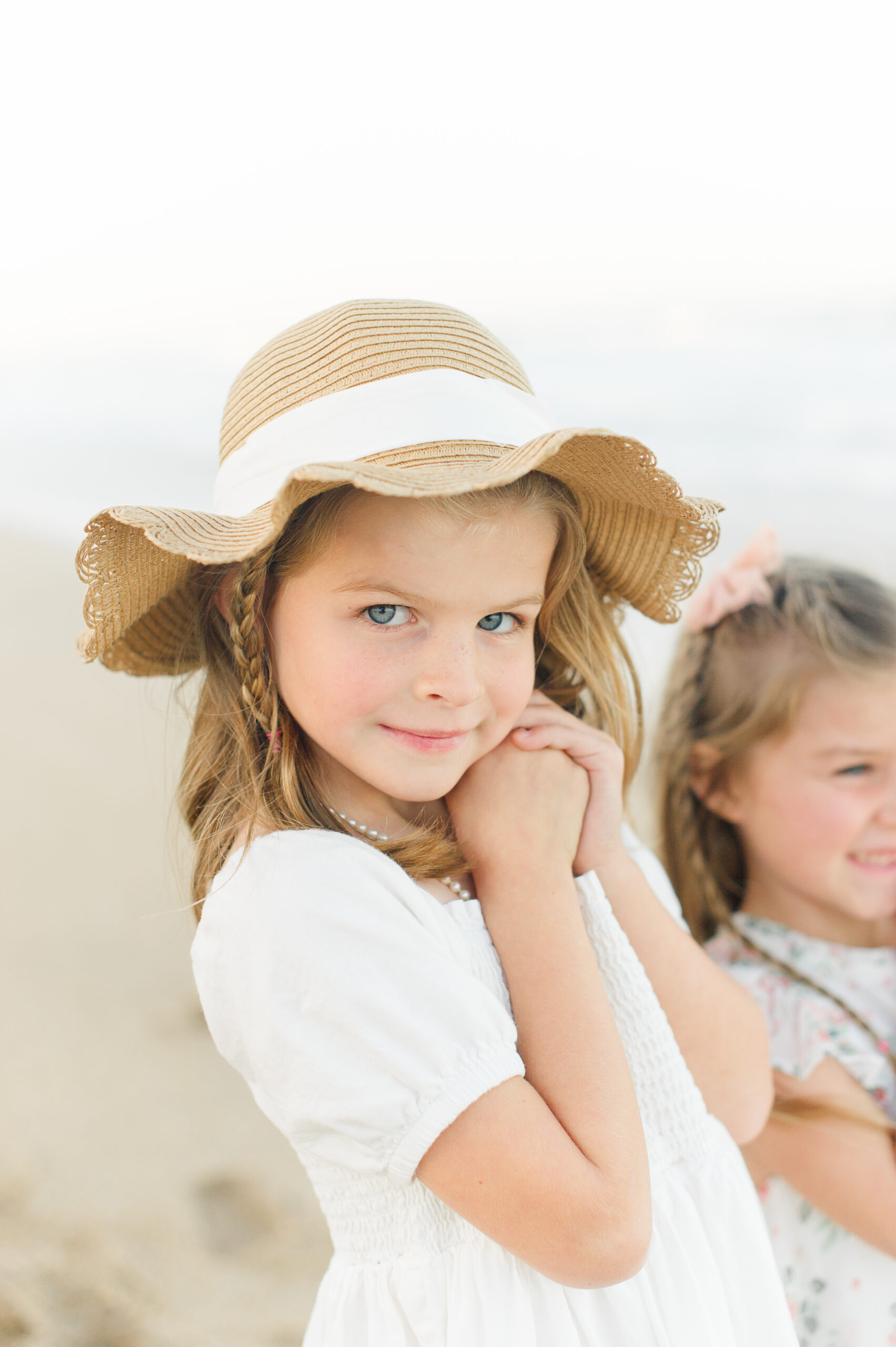 Up close image of a beautiful girl wearing a floppy hat on the beach during her family beach photos on the East coast of Florida