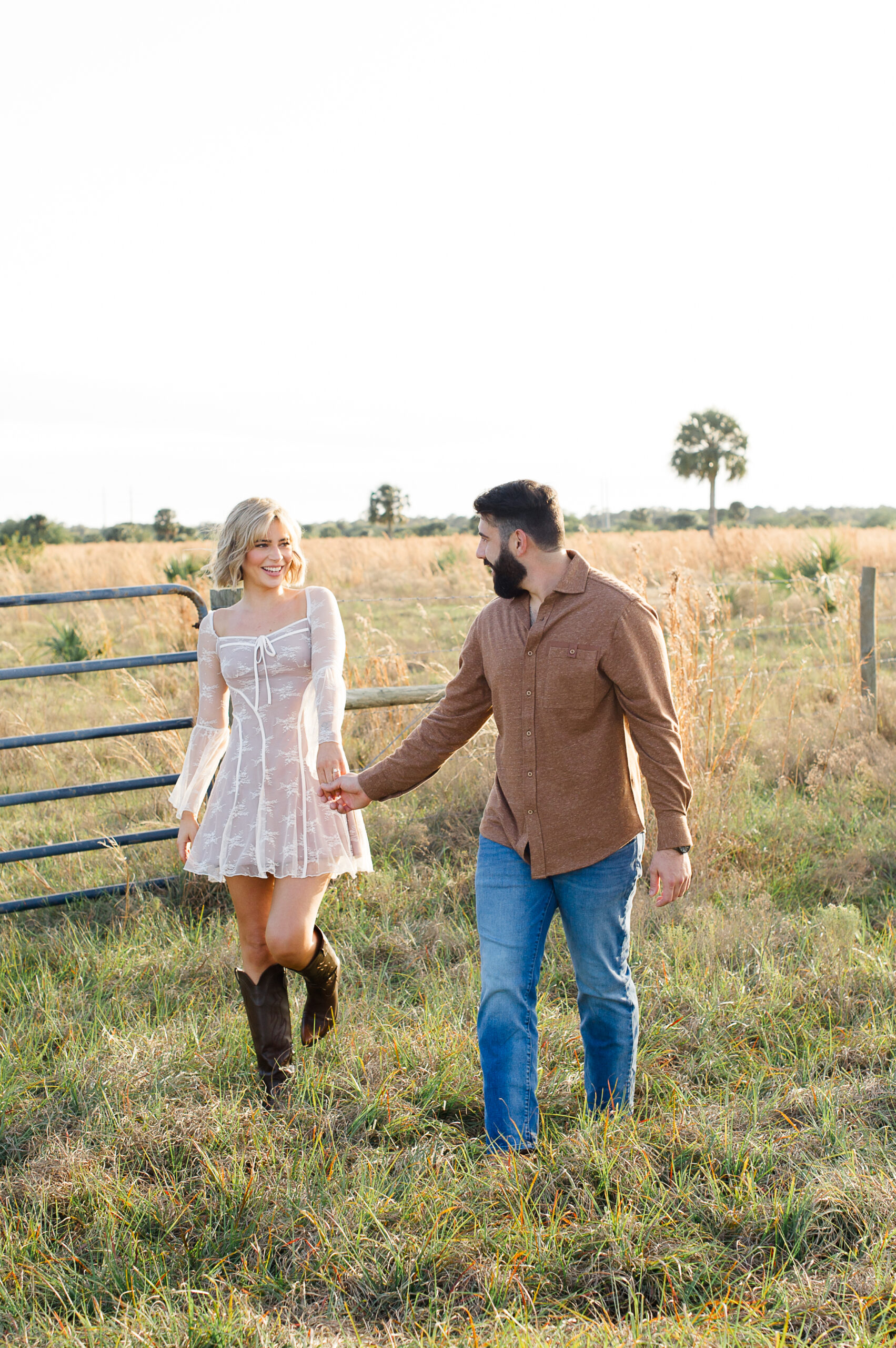 Stunning engaged couple walking through a field of tall grass!