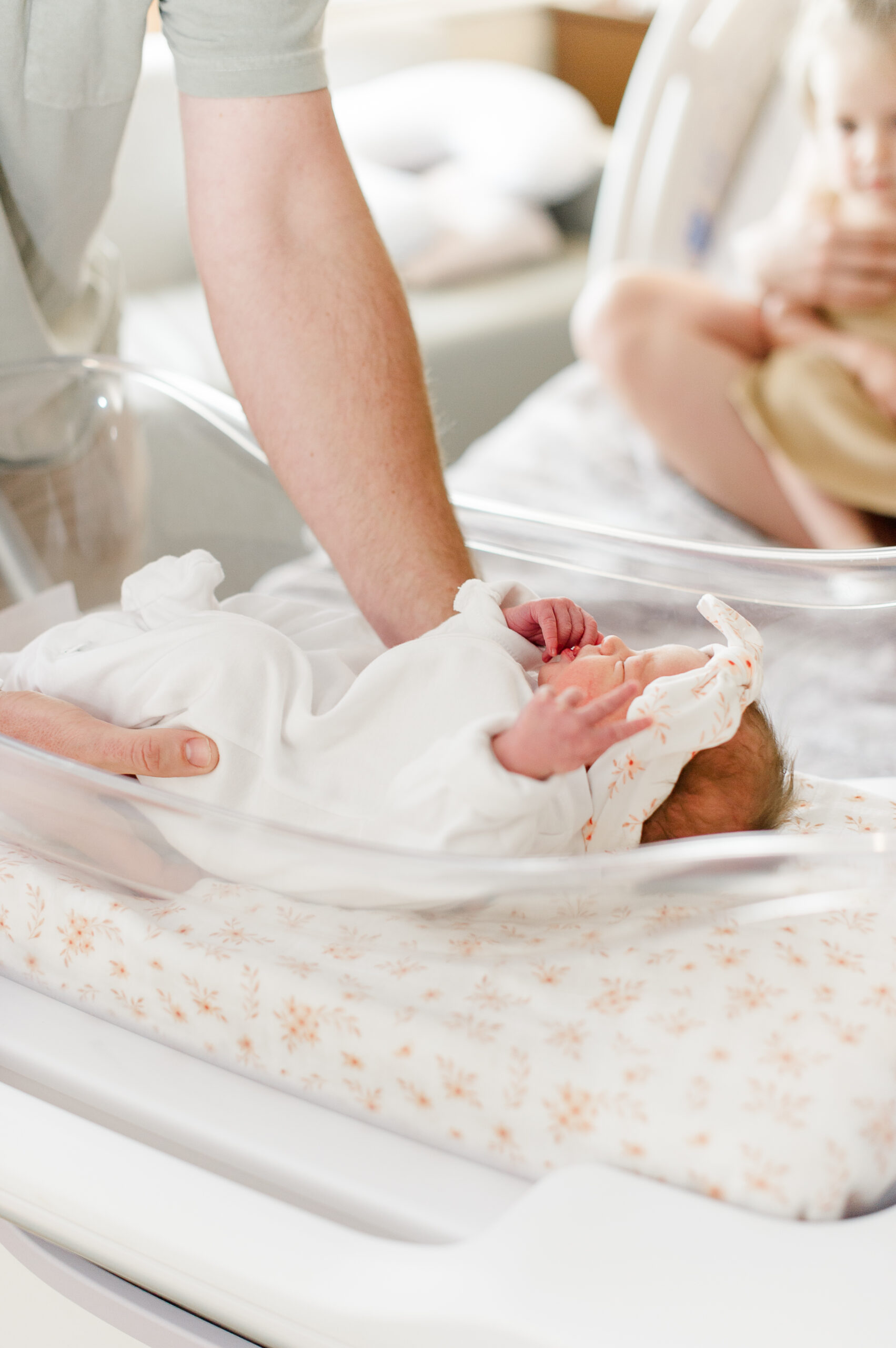 Daddy of a newborn baby girl picks her up out of her bed just a few hours old daycares in Orlando Florida