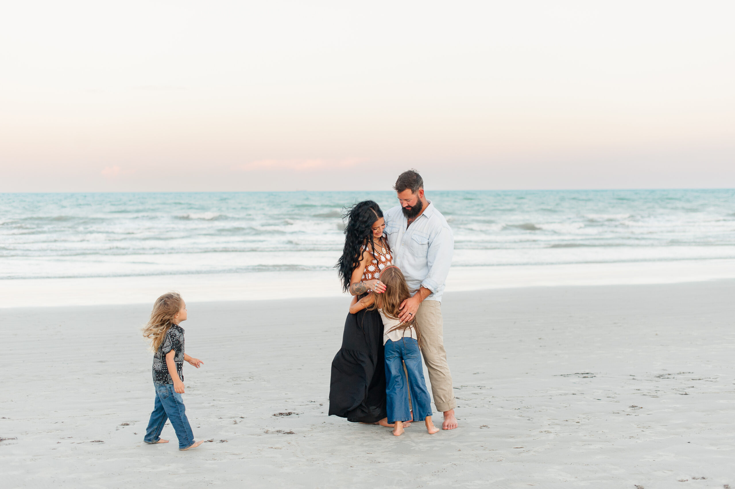 Family hugging on the beach at sunset at Jetty park Beach!